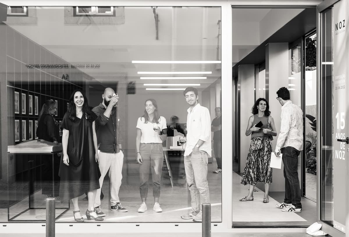Black and white view through the NOZ studio shopfront of guests at the 15 years of NOZ exhibition opening