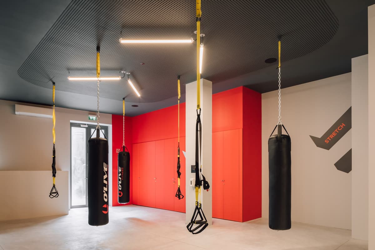 Functional training room with punching bags and suspension straps, red cabinet wall and STRETCH graphic