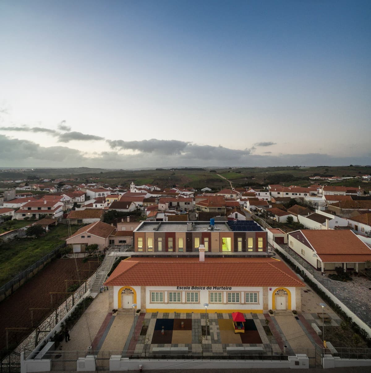Aerial view at dusk of the Murteira primary school, the original tiled building in front of the new brick block